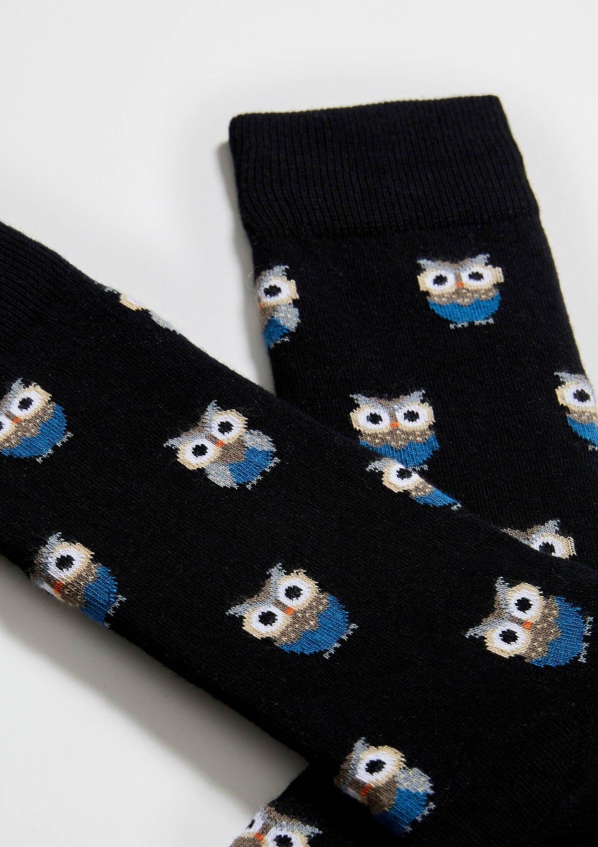 Calcetines BeOwl con fondo negro y búhos en tonos neutros y azul índigo, altura media caña.