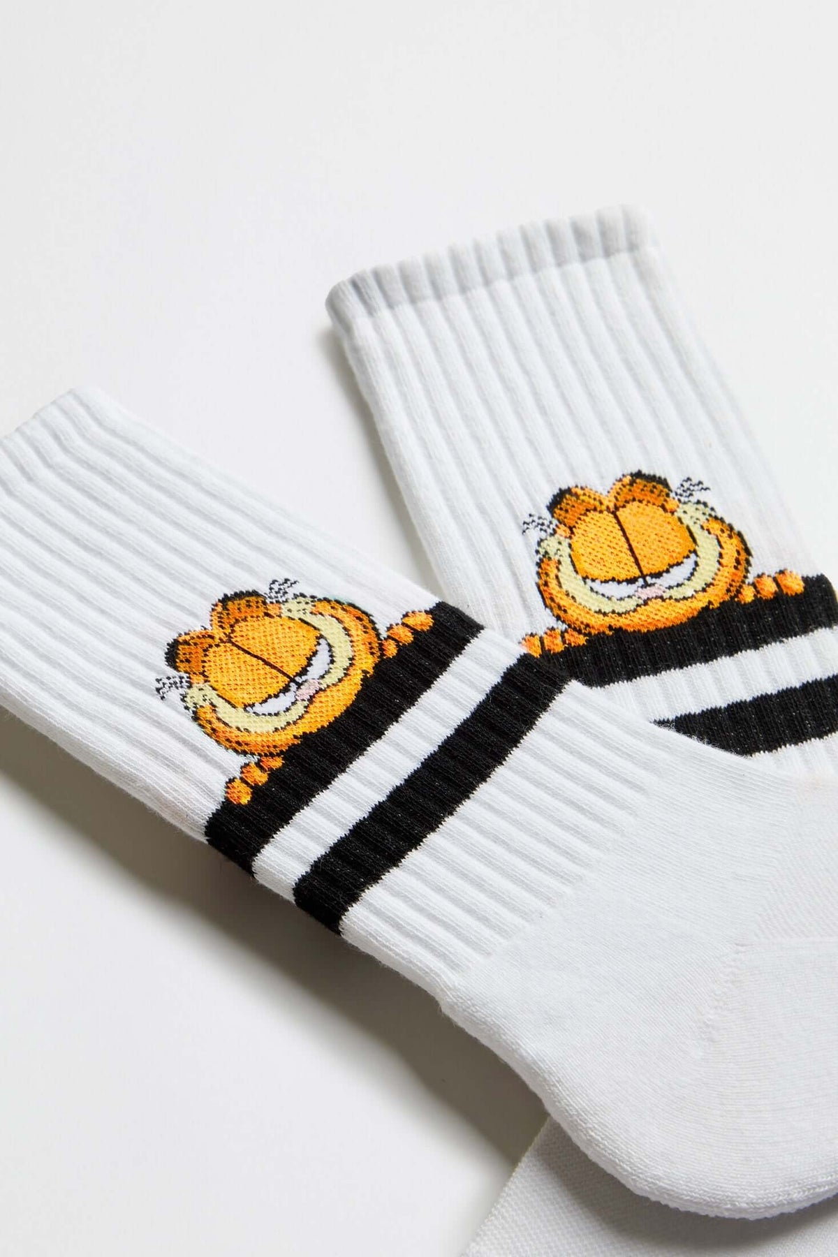 Calcetines BeGarfield Stripes White en blanco con estampado de Garfield y rayas negras, estilo media caña.