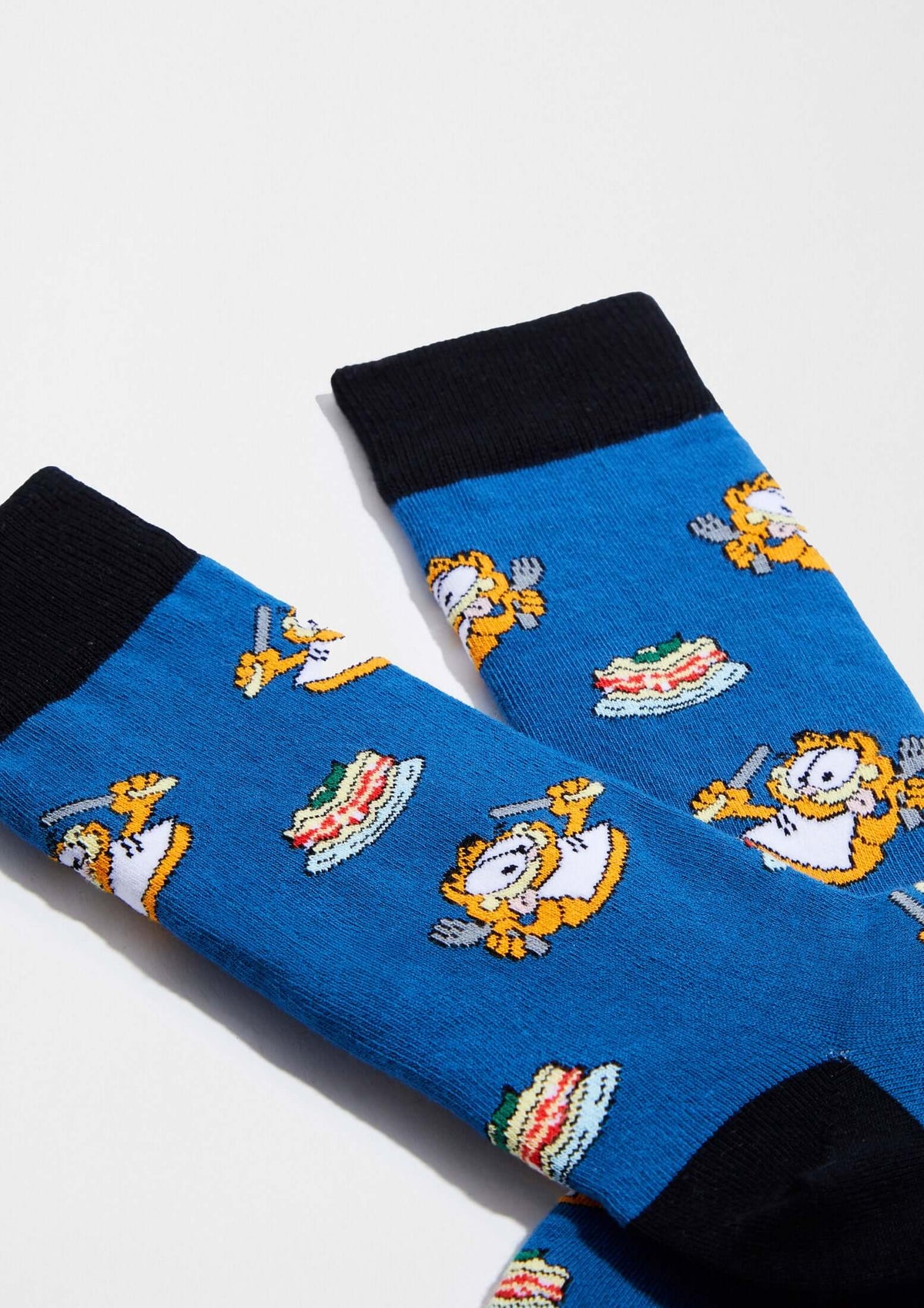 Calcetines BeGarfield Foodie en azul con dibujos de Garfield y platos de lasaña, estilo media caña y puño negro.