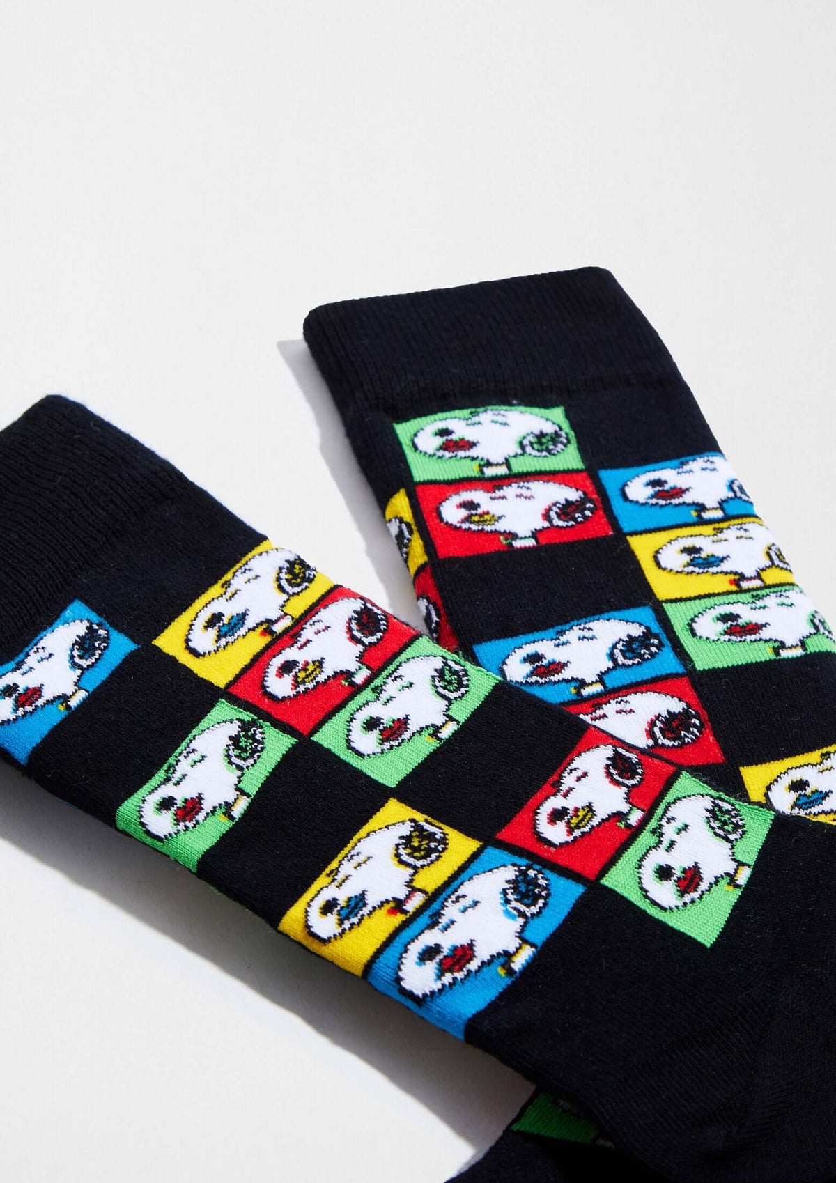 Calcetines BeSnoopy Pop Art en negro con diseño de cuadros de Snoopy en rojo, azul, verde y amarillo, su altura es media caña.