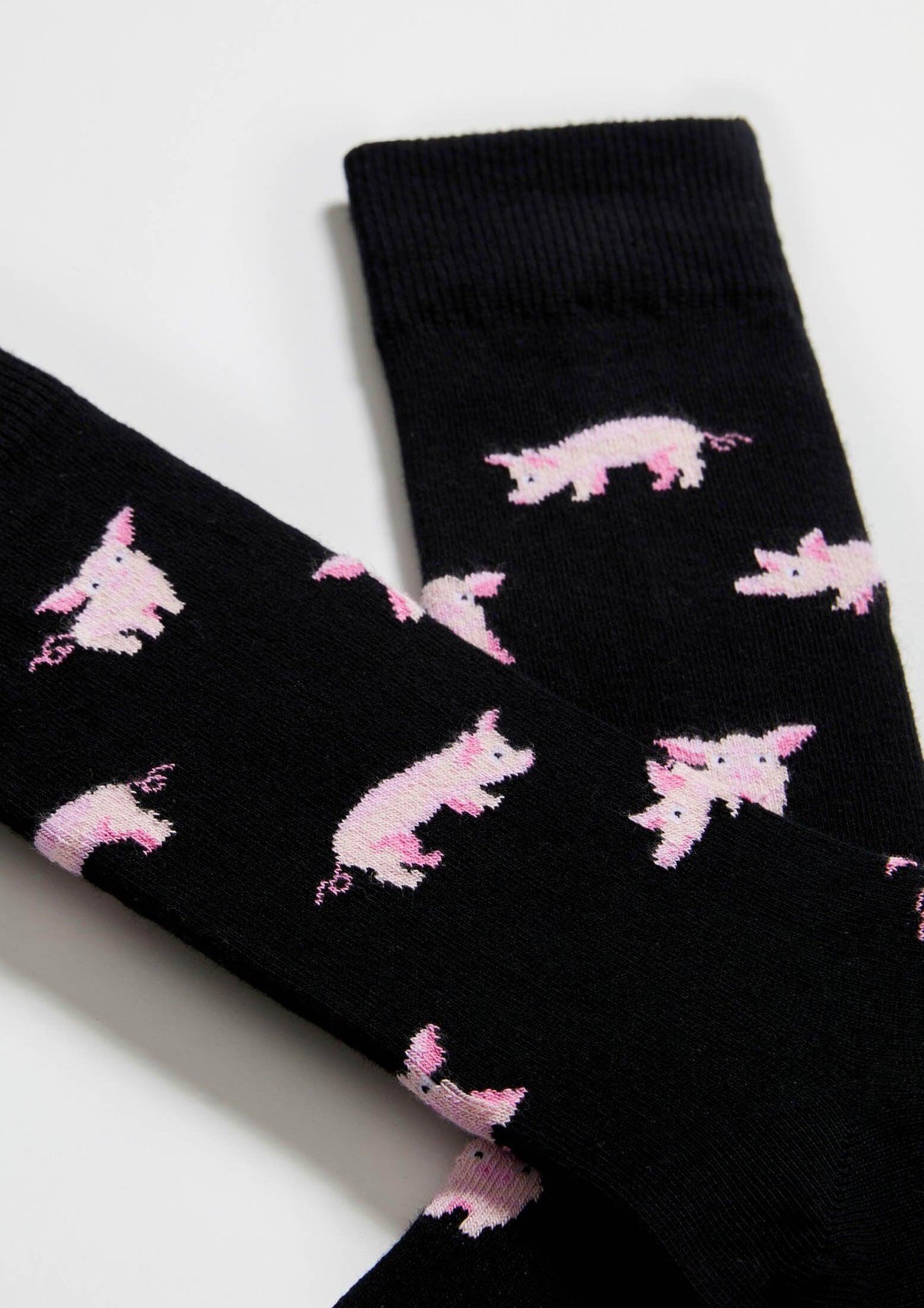 Calcetines BePig en negro con dibujos de cerdos rosas en varias posturas, de altura tobillera.