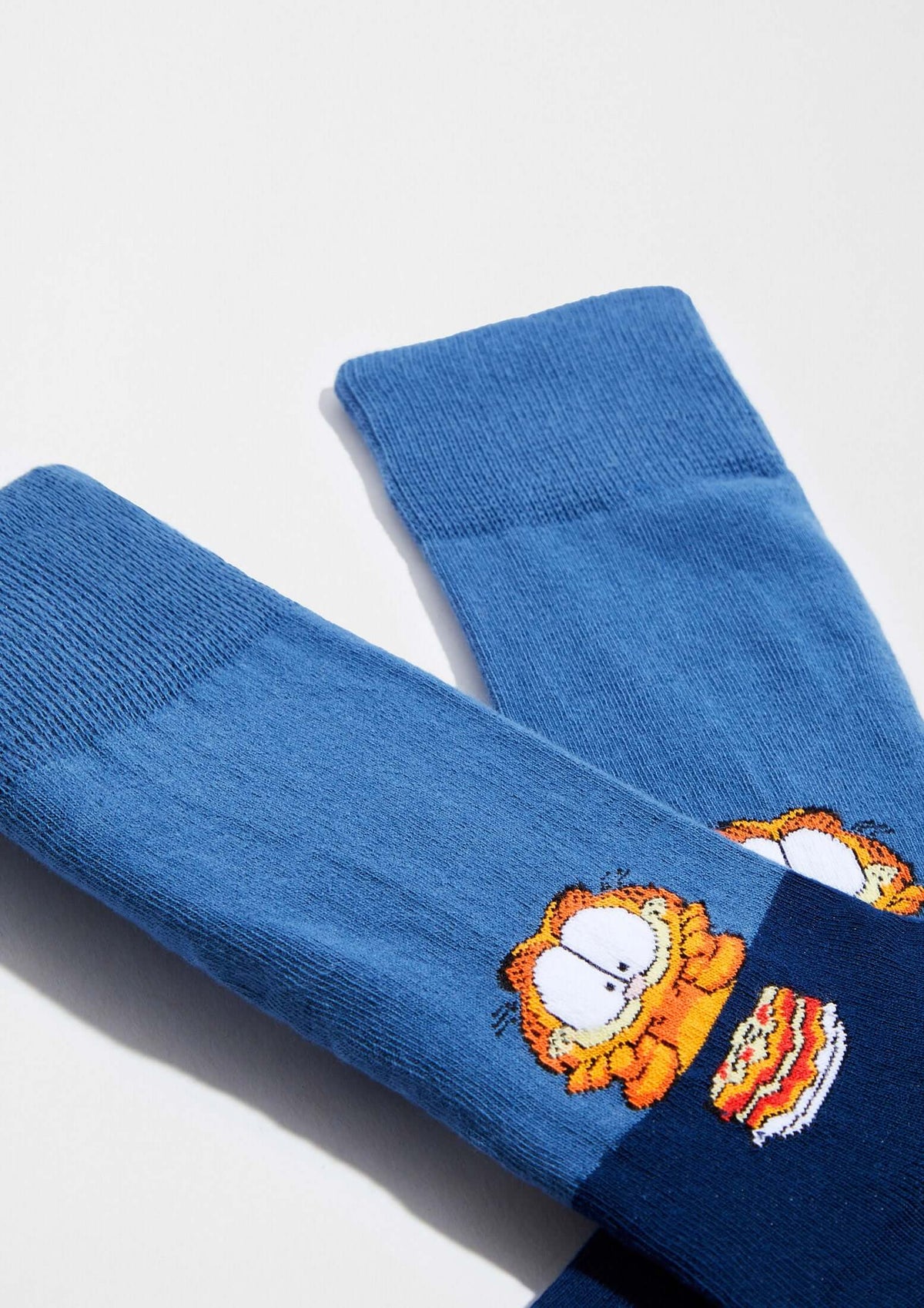 Calcetines BeGarfield Lasagna en azul con dibujo de Garfield sobre lasaña, altura tobillero, diseño color block.