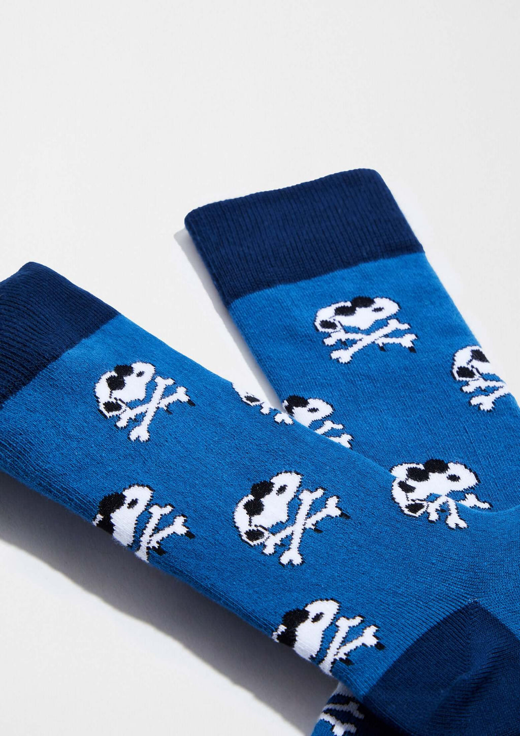 Calcetines BeSnoopy Skull Blue con fondo azul intenso y calaveras de Snoopy, altura media caña.