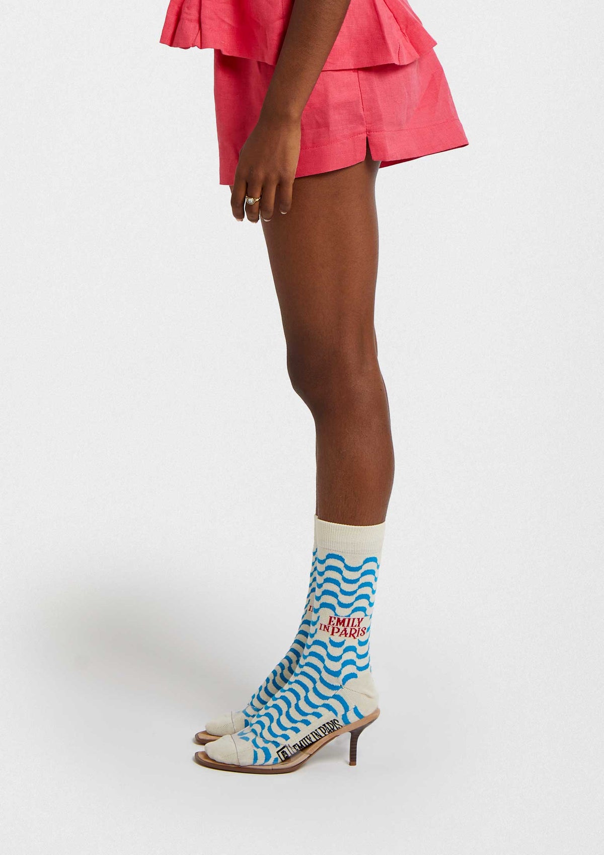 BeEmilyinParis Waves calcetines con dibujos en color crudo y ondas azules, combinados con un outfit veraniego.