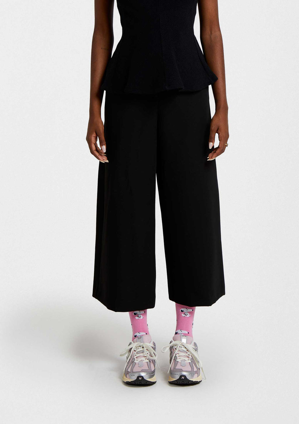 Calcetines BeSnoopy Pink de caña baja en rosa con estampado de Snoopy en varias posiciones, combinados con pantalones negros.
