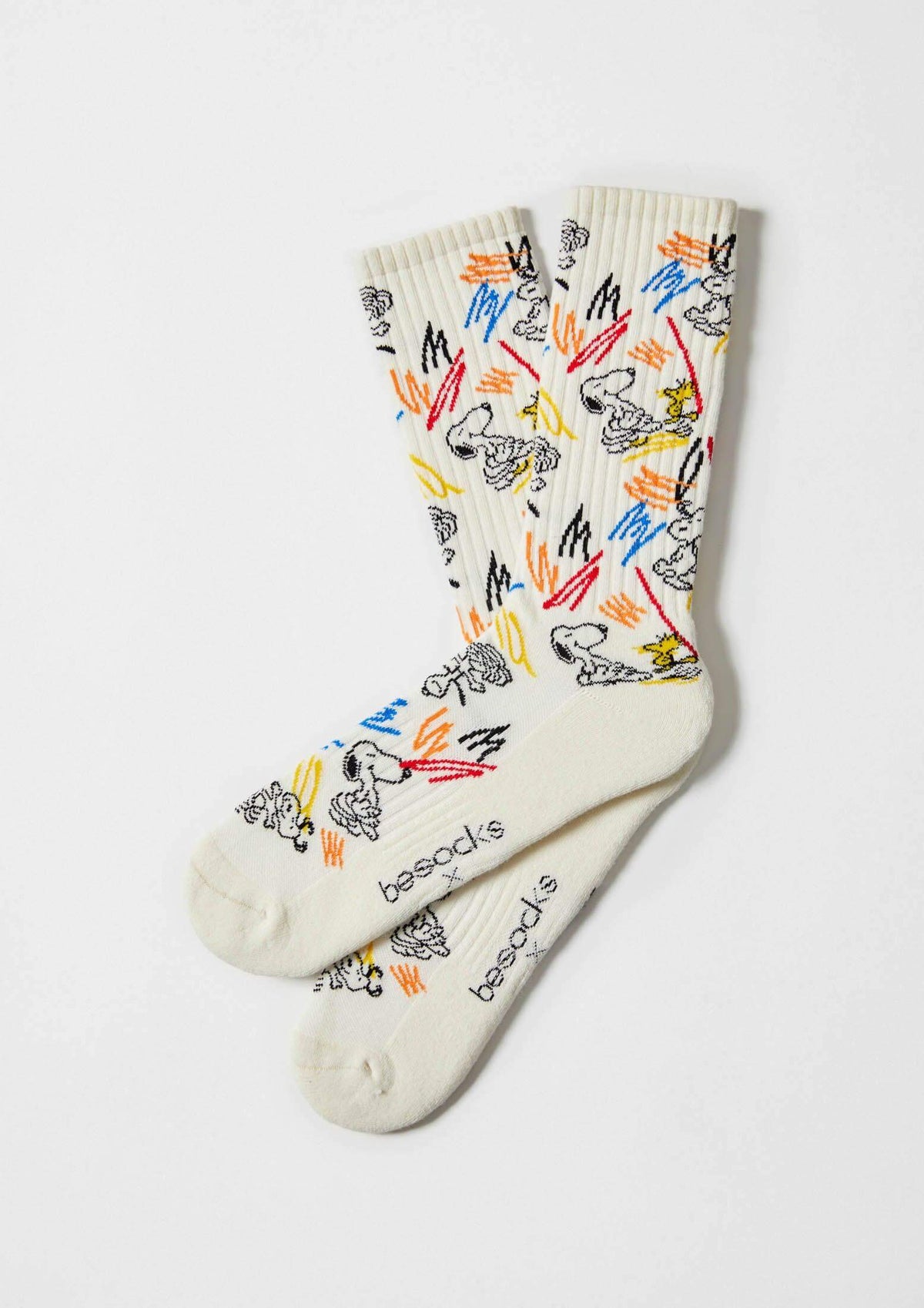 Calcetines BeSnoopy Paint beige con dibujos de Snoopy y Woodstock en colores sobre fondo claro, altura media caña en algodón orgánico.