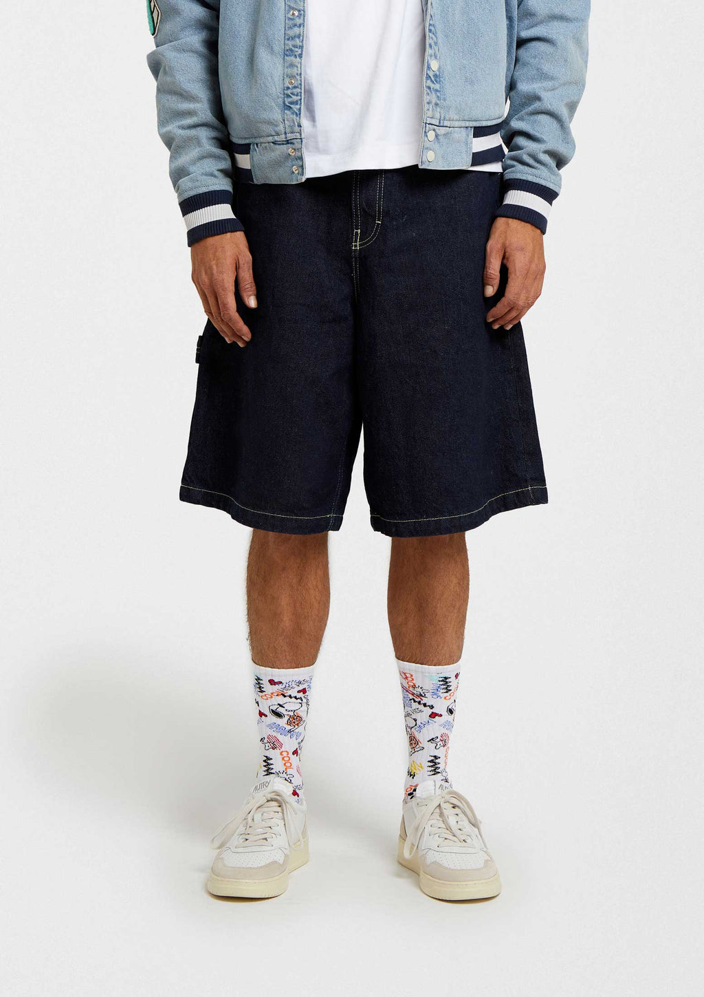 Calcetines BeSnoopy Urban en blanco con dibujos coloridos, altura tobilleros, combinados con pantalones cortos azul oscuro.